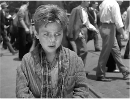 Figure 6.7 Bicycle Thieves (De Sica, 1948): medium tracking shot. De Sica places Bruno’s face in a medium tracking shot that reveals the boy walking and dusting off his father’s hat, a tearful accomplice to his shameful theft. Source: Copyright 1948 Ente Nazionale Industrie Cinematografiche.