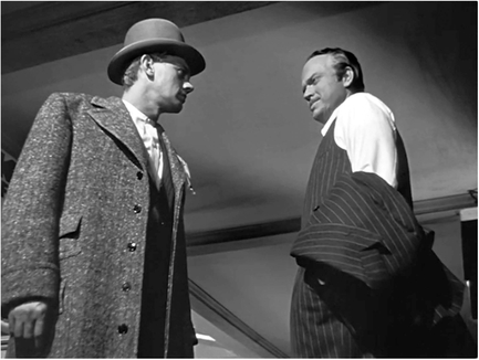 Figure 8.7 Internal rhythm: low angle placement in Citizen Kane (Welles, 1941). With character movement minimal, the low placement in this scene helps to energize the internal rhythm of the dialogue and movements of Kane (Orson Welles) and Jedediah Leland (Joseph Cotten) as they stare each other down. Source: Copyright 1941 RKO Radio Pictures.