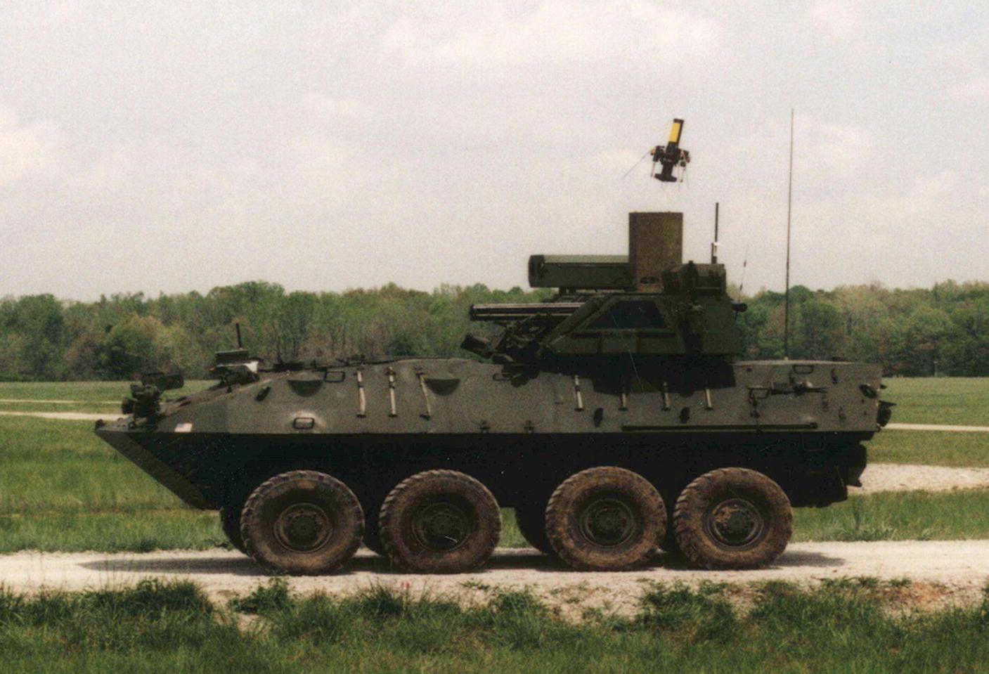 Photo displaying XQ‐138 hovering missile prototype performing battle damage assessment on a US Army Future Combat System prototype;Redstone Arsenal, Alabama, 2002.