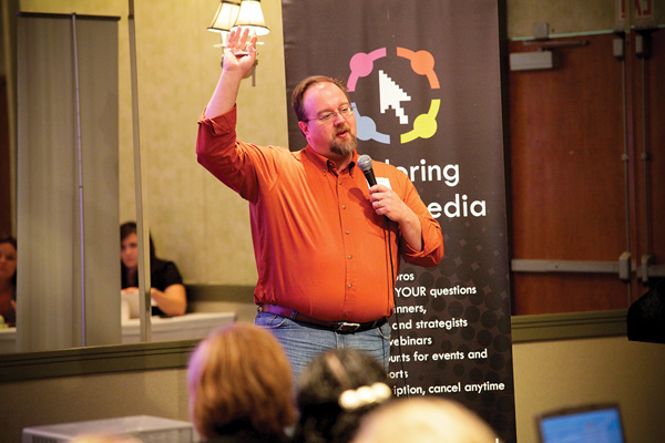 A screenshot shows a photo of Erik speaking at a conference.