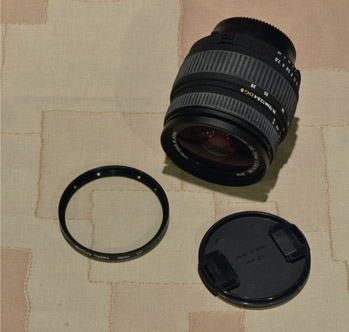 Figure 19.6: Nikon camera lens with UV filter and lens cap. Note that the UV filter has no effect on the color or sharpness of the fabric it sits on.