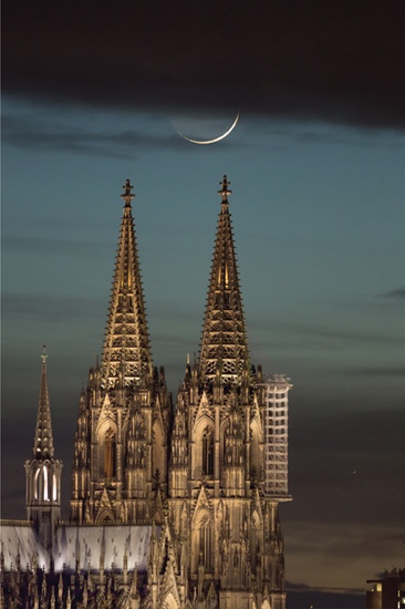 15.8 The waxing crescent moon and a crescent Venus (lower right) set gracefully over the Cologne Cathedral in Germany.