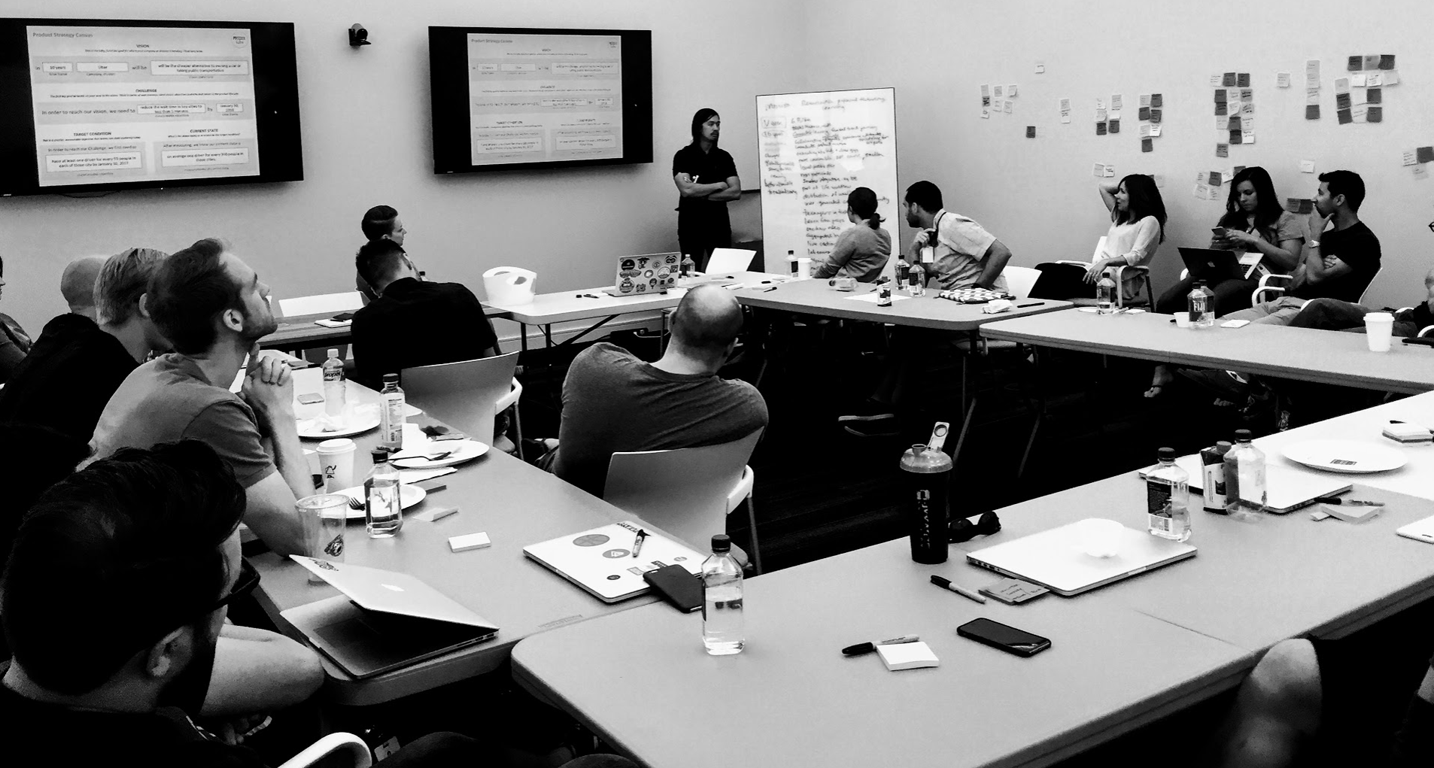 Gilbert Lee (center, standing) working with the Pluralsight product management and user experience team. At Pluralsight each product team is cross-functional and collocated. Every week the team gathers for two hours and works on each other’s experiences to arrive at the best outcomes for each experience.