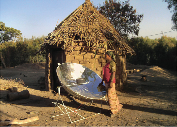 The illustration shows a solar cooker with a woman standing in front of it.