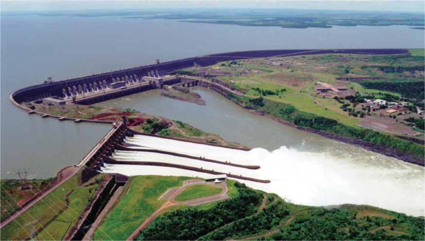 The illustration shows an aerial view of the Itaipu power plant. Water flows down the dam from high potential.