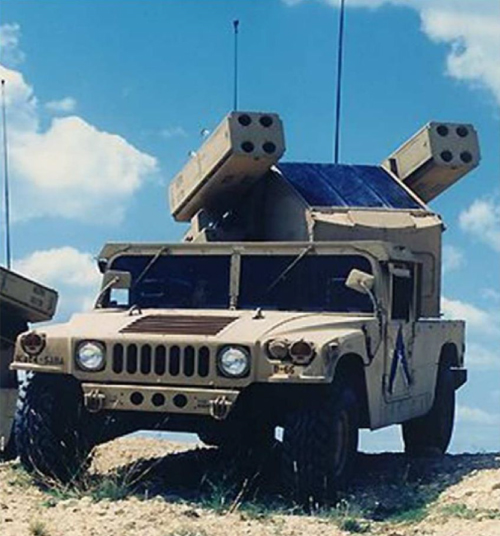 Photograph of the US Army's short-range air defense weapon, Avenger, that has a missile operator in a turret on the back of a small truck.