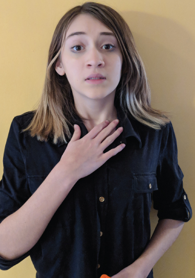 Photograph of a girl covering her suprasternal notch with her right hand indicating fear.