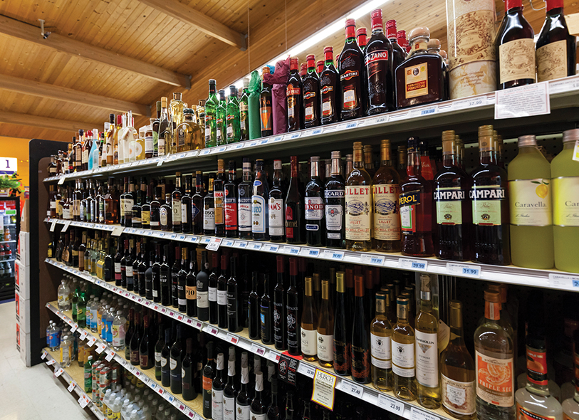 Image shows a row of wine bottles on wine rack.