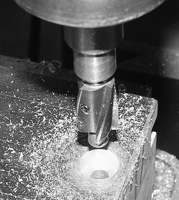 Photograph of a milling machine with a counter bore tool making a recess around the top of a hole is shown.