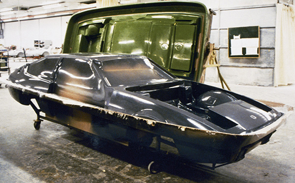 photograph shows the chassis of a car being removed from a mold.