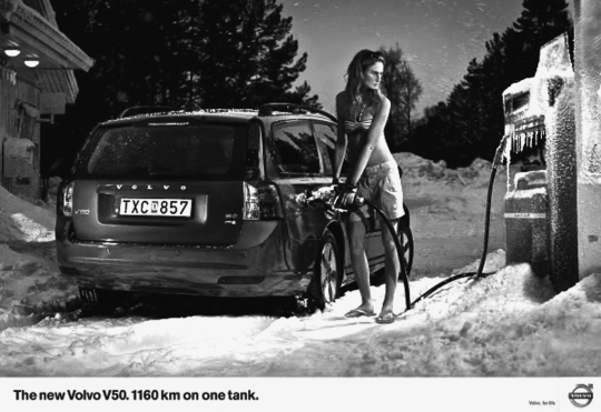 Figure depicting an ad for Volvo where a lady wearing swimwear is filling her car at a gas station in some cold and snowy area. The ad headline reads “The new Volvo V50. 1160 km on one tank.”