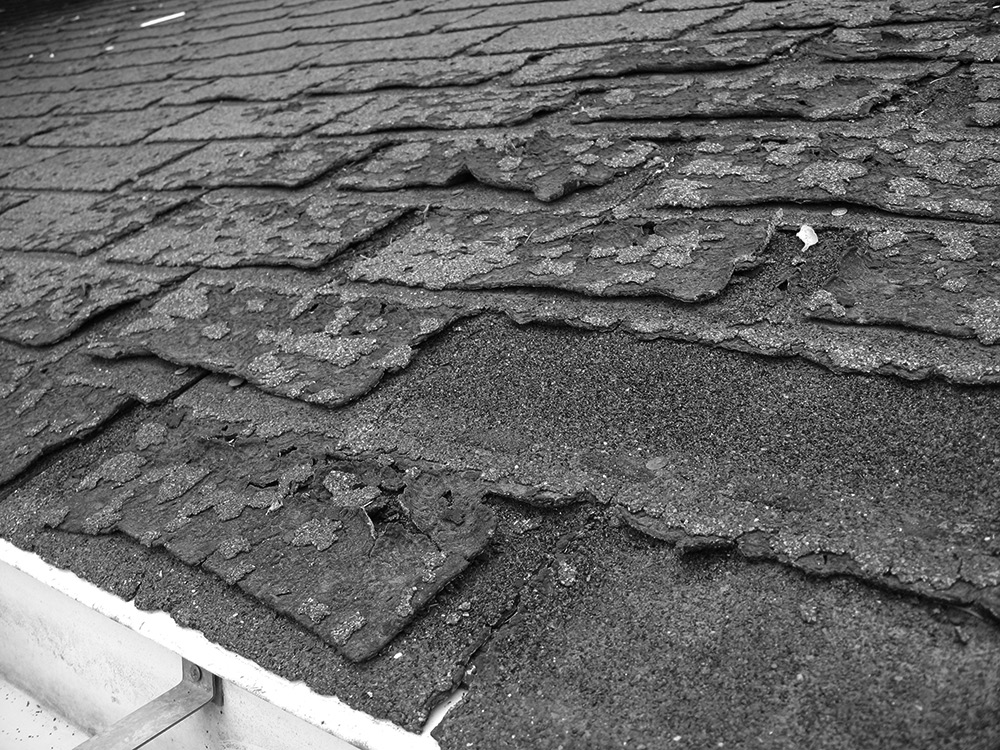Image of Heavily weathered asphalt shingle roof.