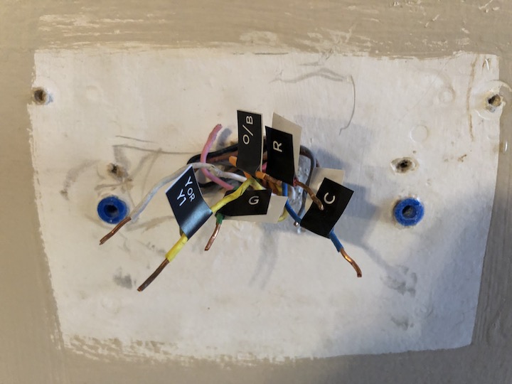 Figure 58: The ecobee thermostat without the trim plate wasn’t enough to cover this mess! Note the unused wires that I’m ignoring. You also probably want to remove any unused drywall anchors to ensure an even surface for the thermostat and plate to rest on.