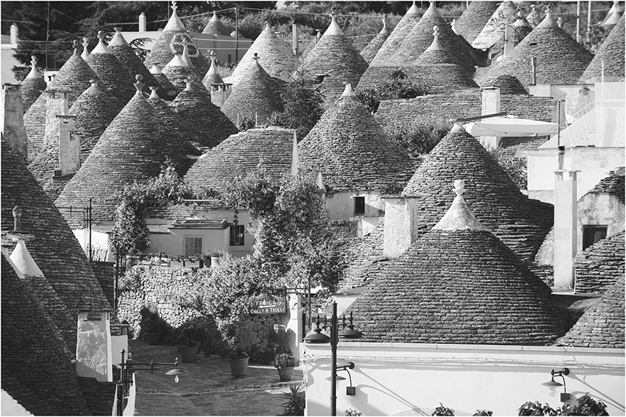 A village of houses with cone-shaped roofs built from bricks.