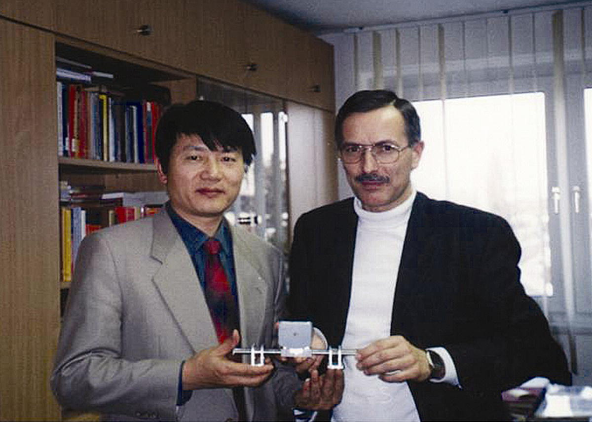 Photo of Professor Xiaoting Rui (left) standing beside Professor Kluse Zimmermann (right). Both are holding a device.