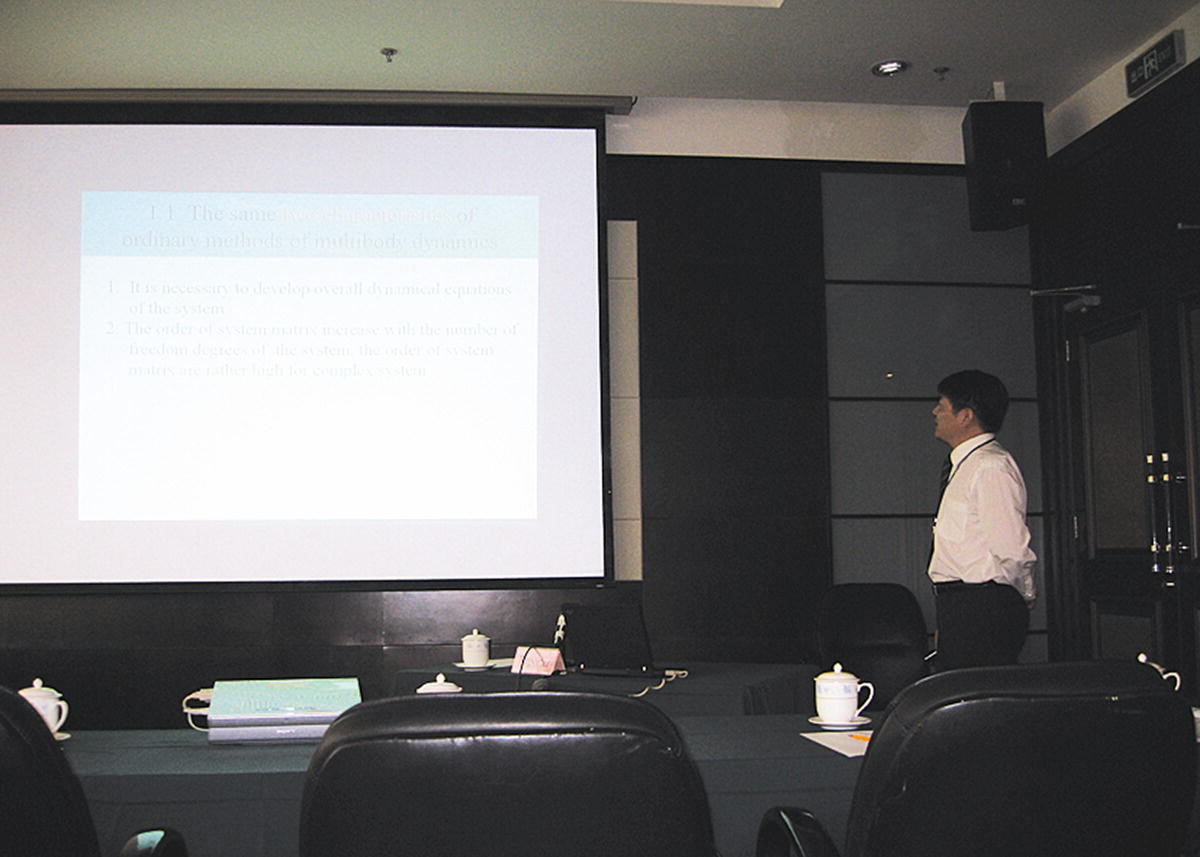 Photo of Professor Xiaoting Rui standing and facing the projector screen.