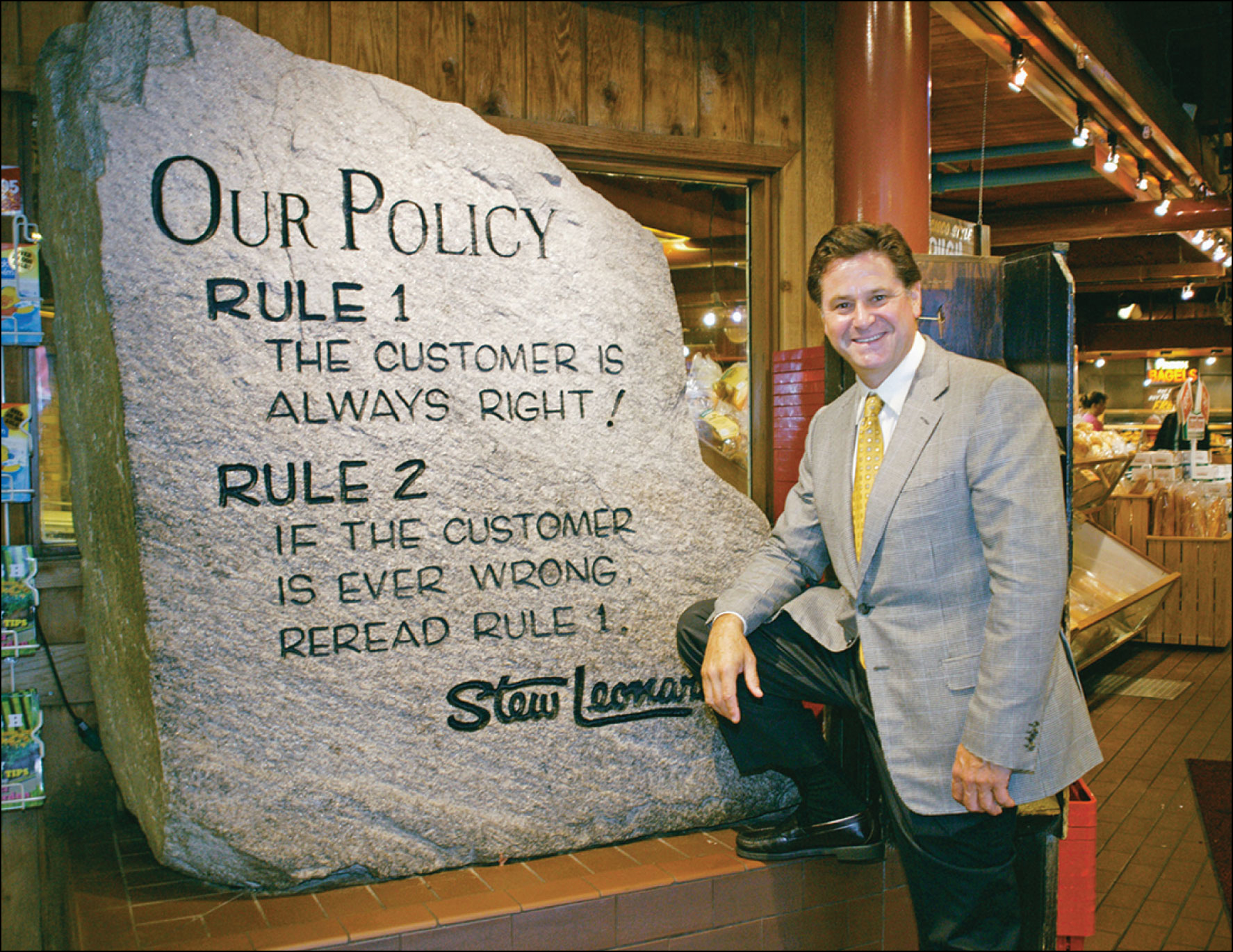 A photo shows Stew Leonard standing next to a huge stone that carries the text “Our Policy Rule 1 - The customer is always right! Rule 2 - If the customer is ever wrong, reread rule 1. - Stew Leonard.”