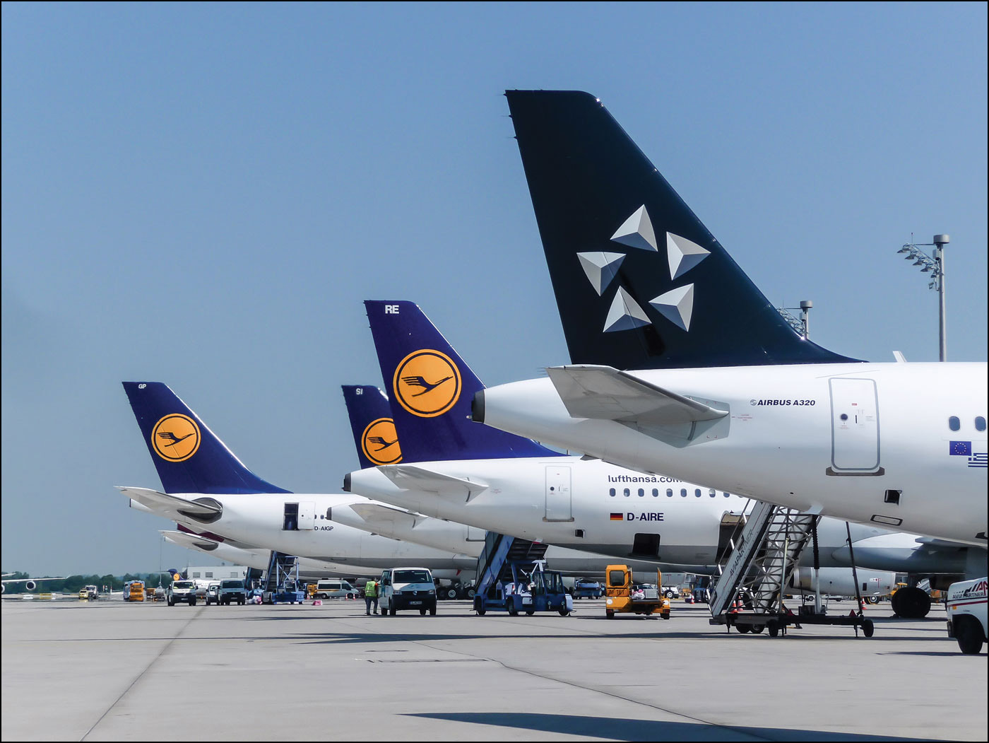 A photo shows the tails of a number of airplanes of Lufthansa Airlines on a tarmac.