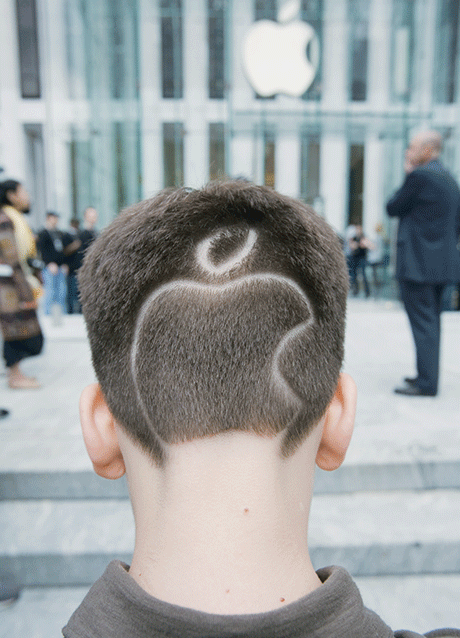 Photo shows the back of a man’s head with the Apple logo shaved into his hair.