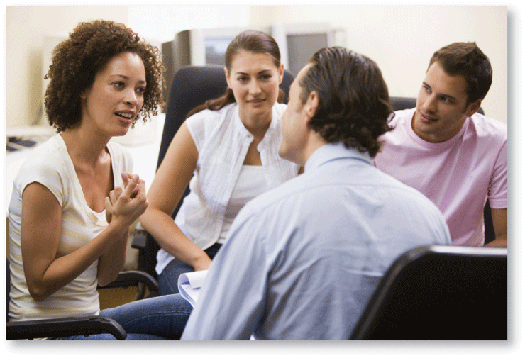 A photo shows a young woman talking to a man while another couple is listening in.