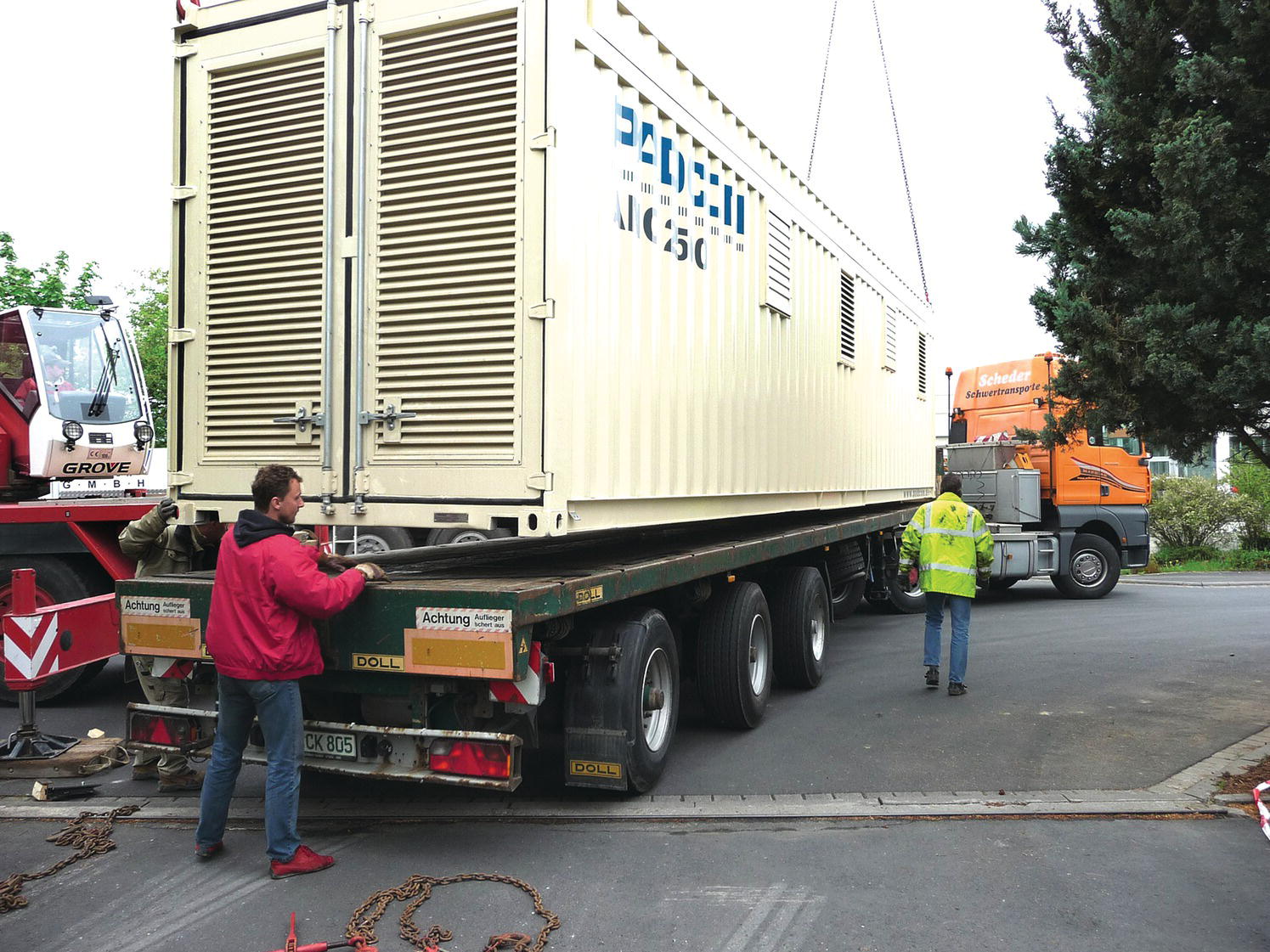 2 Men assisting a 1.6 MWp inverter on a truck.