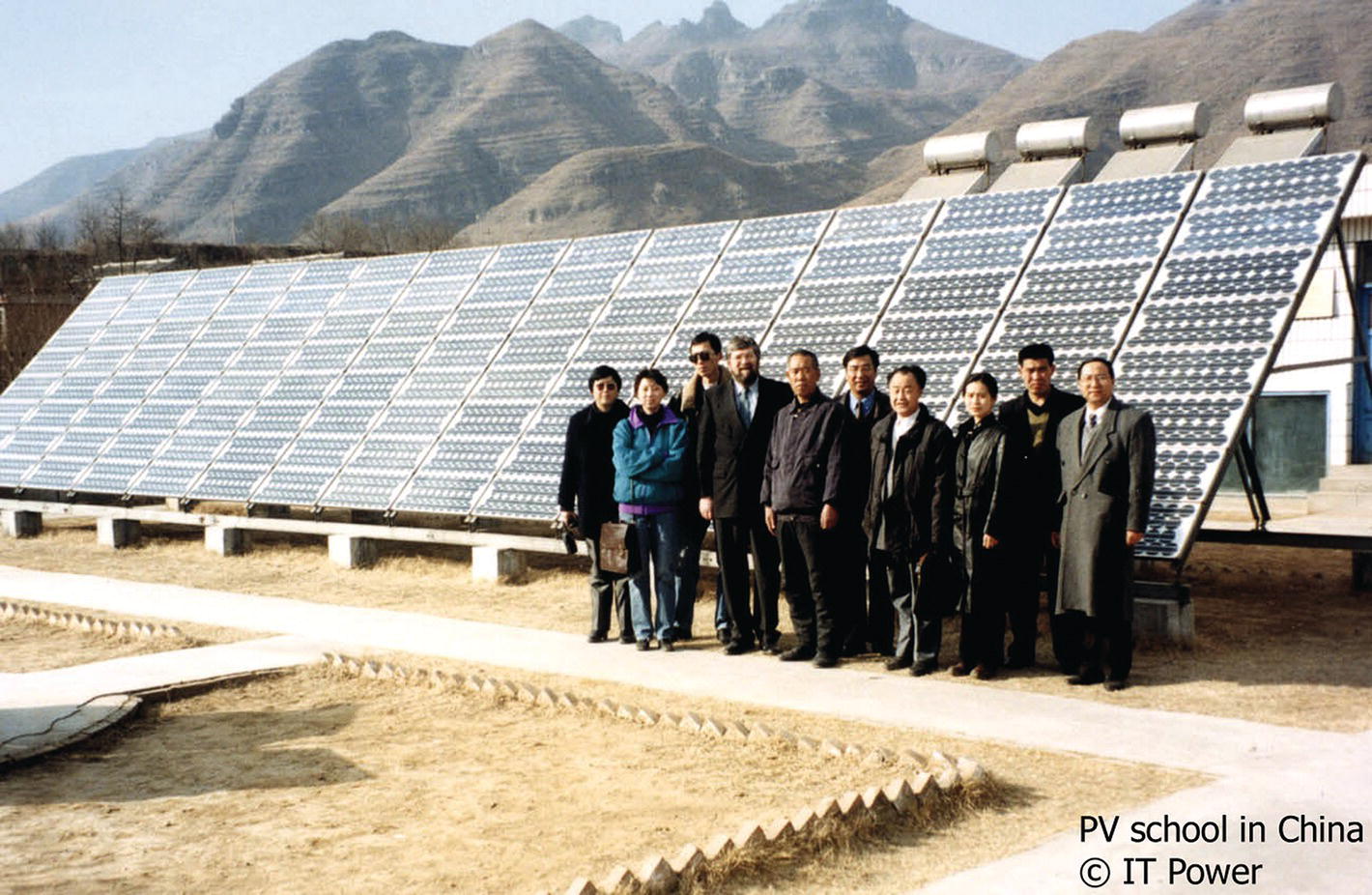 Ten people standing with the PV arrays as their background.