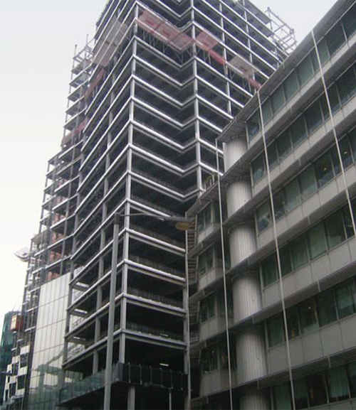 Photo showing Steel frame nearing completion, and façade commenced.